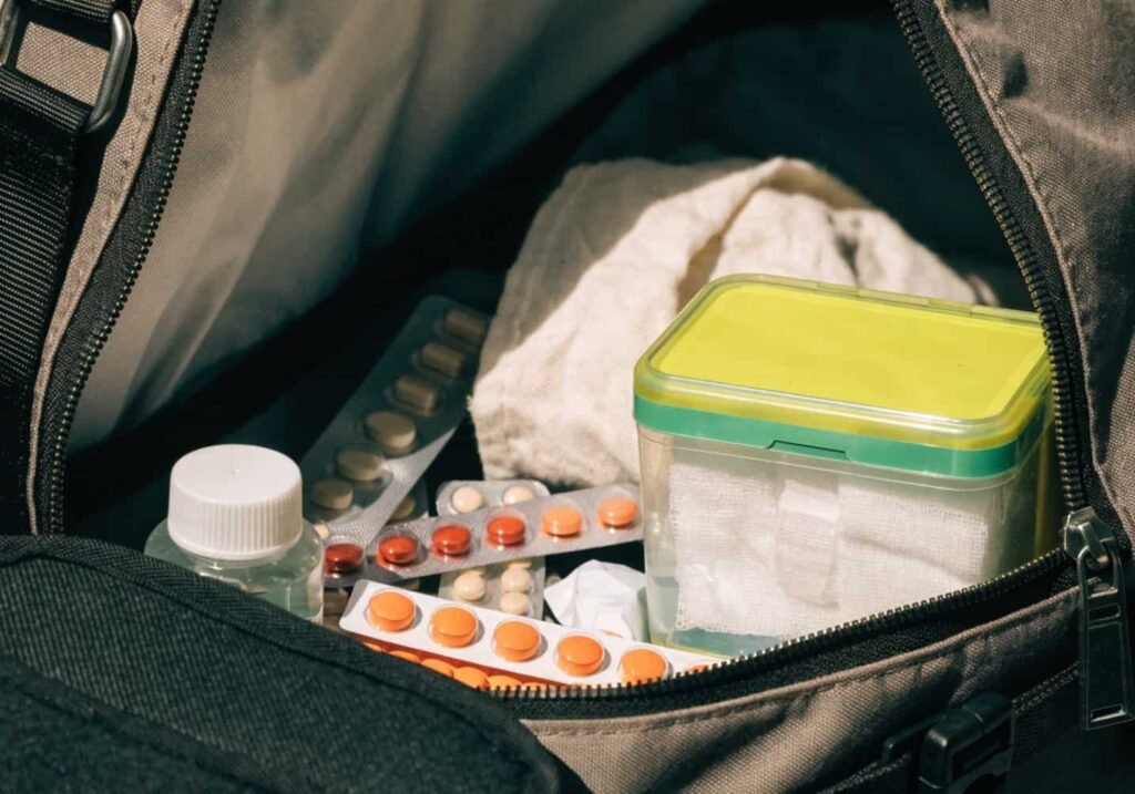 Small first-aid kit and medicine packed for health and safety while traveling.