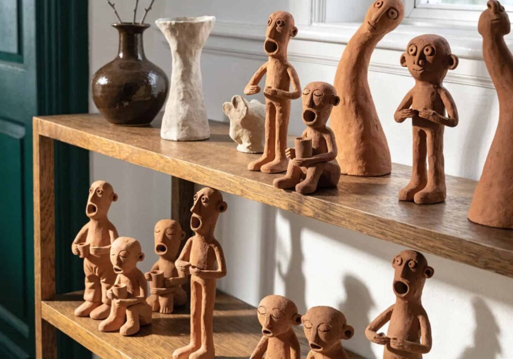 Well-styled shelf showing clay figures grouped at varying heights