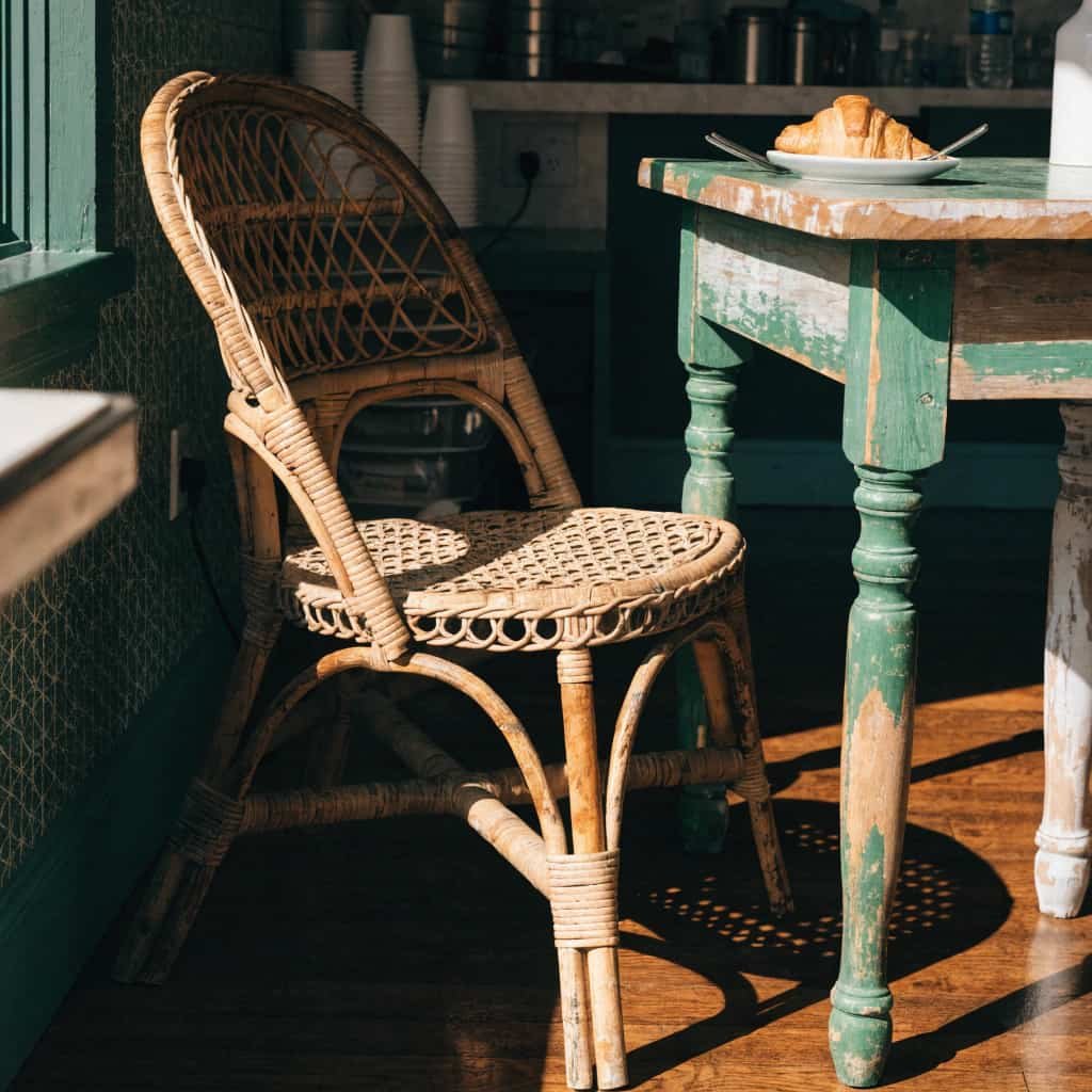 budget-friendly cafe corner with thrifted rattan chair and table