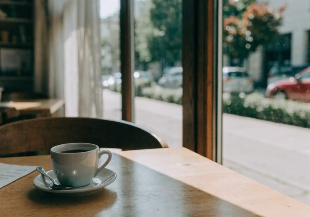 Soft natural daylight through a cafe window onto a coffee table