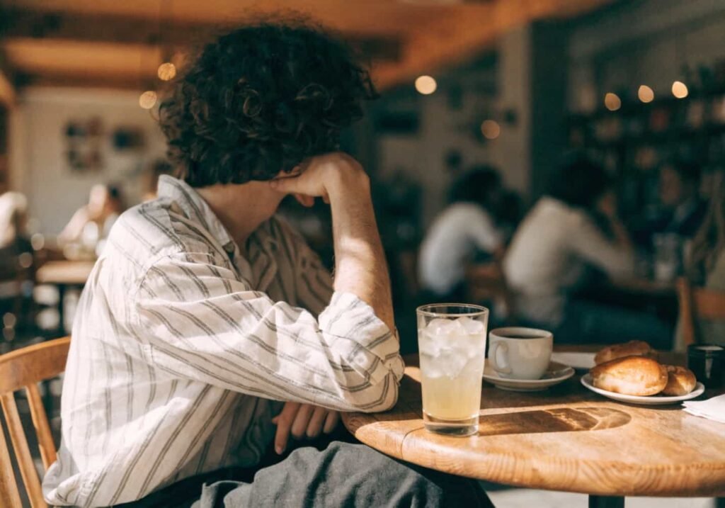 Person photographed from a slight side angle at a cafe.