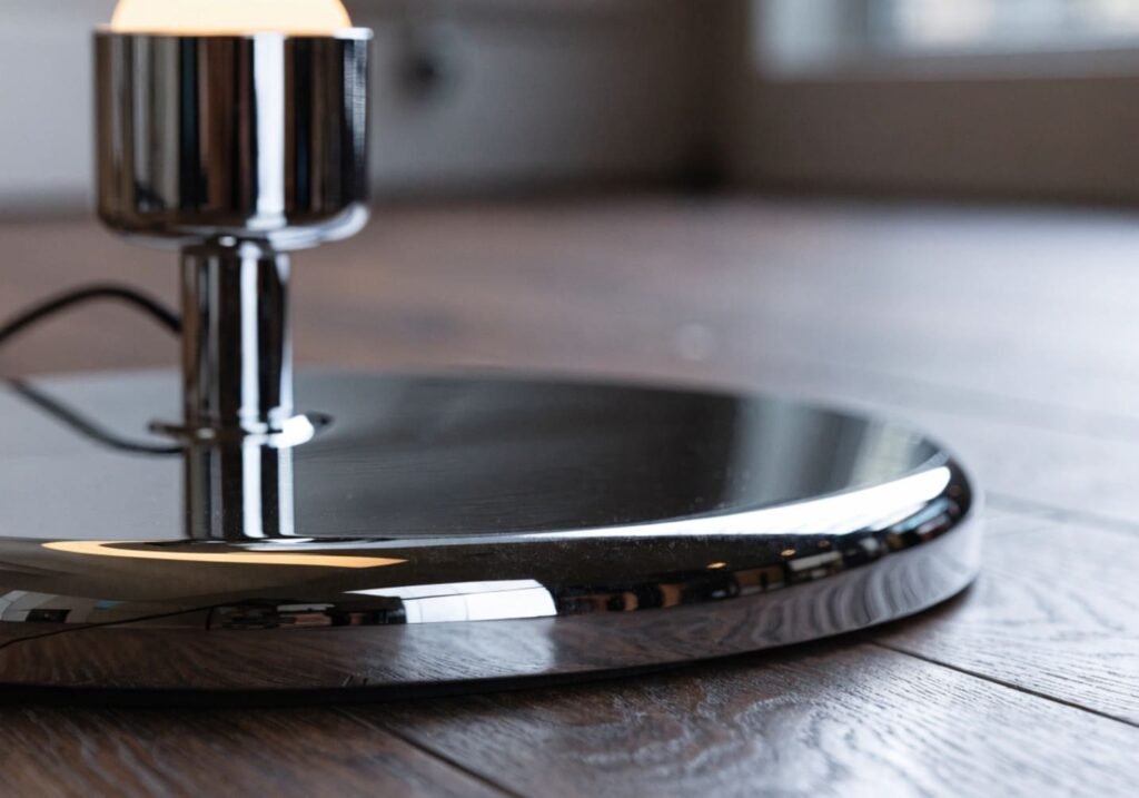 Close-up of a chrome floor lamp base showing its shiny reflective finish