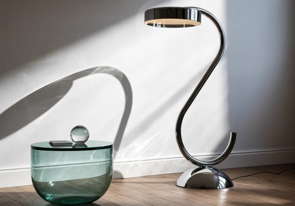 Sleek chrome floor lamp styled with glass table and minimal decor