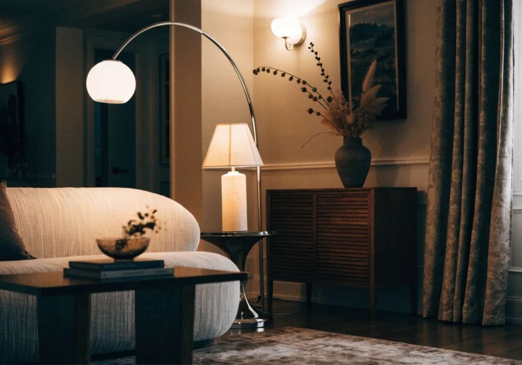 Chrome arc floor lamp as part of a layered lighting setup in a living room