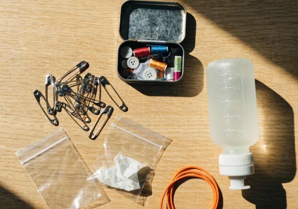 Often forgotten travel items including sewing kit, safety pins, and reusable water bottle.