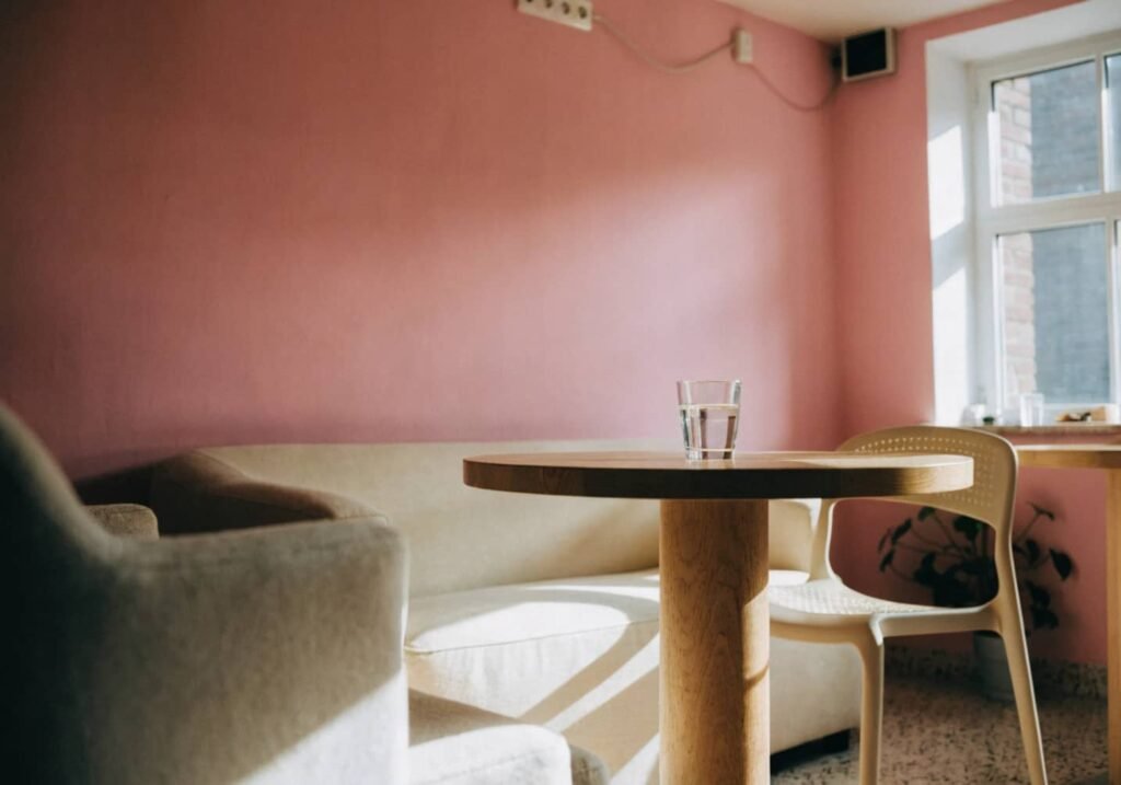 soft pastel pink cafe wall with cream furniture and greenery