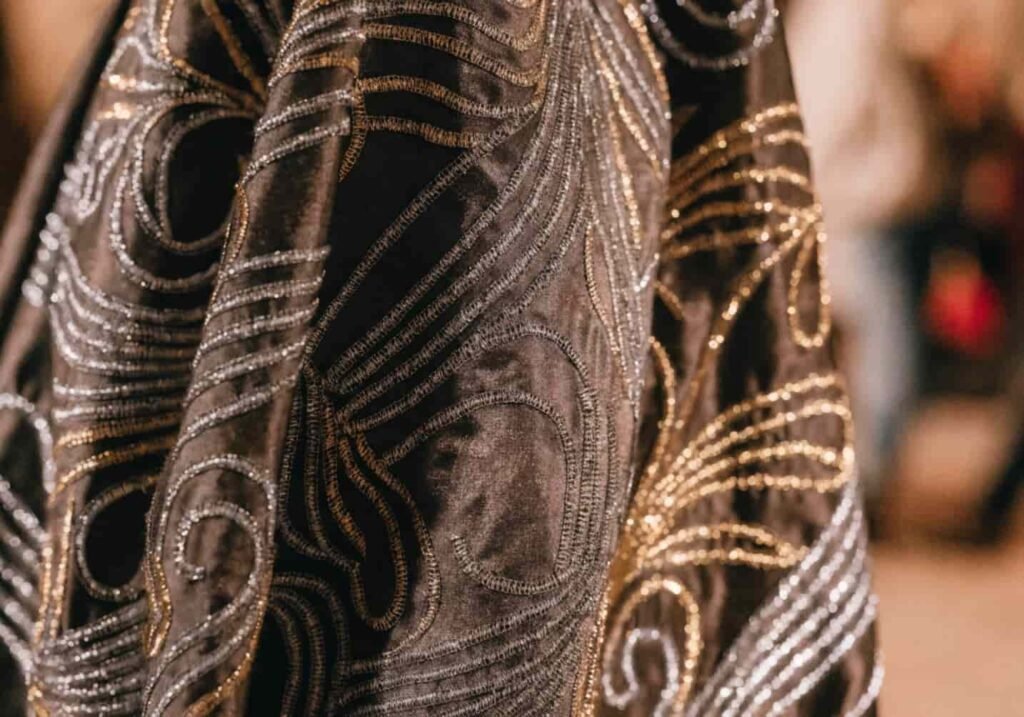 Garment detail showing shimmering metallic thread embroidery catching light