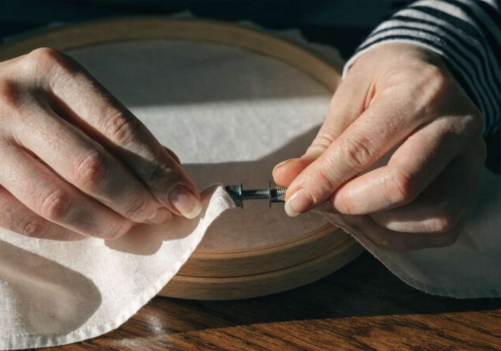 Adjusting embroidery hoop tension for smooth even fabric surface