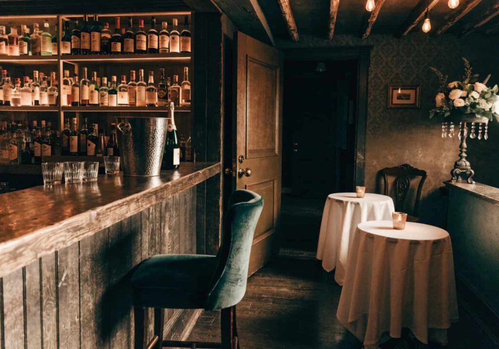 Speakeasy-inspired dark and moody wedding reception setup with vintage bar