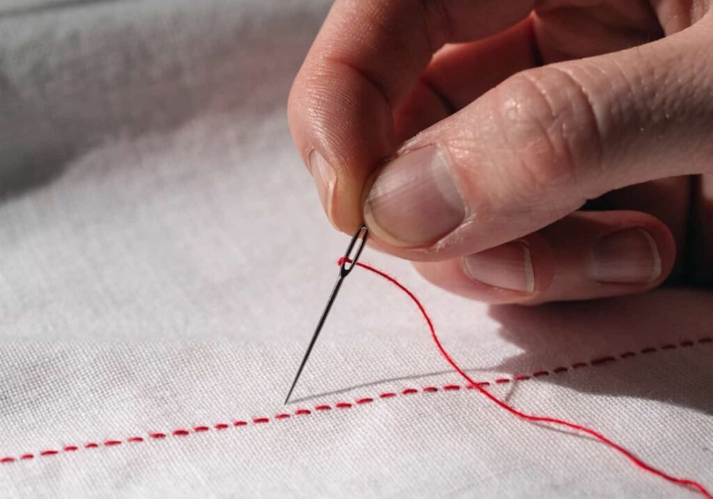 Simple running stitch technique demonstrated on white fabric with red thread