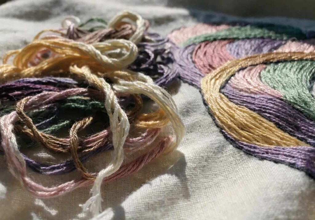 Comparison of tangled embroidery thread versus neatly stitched fabric
