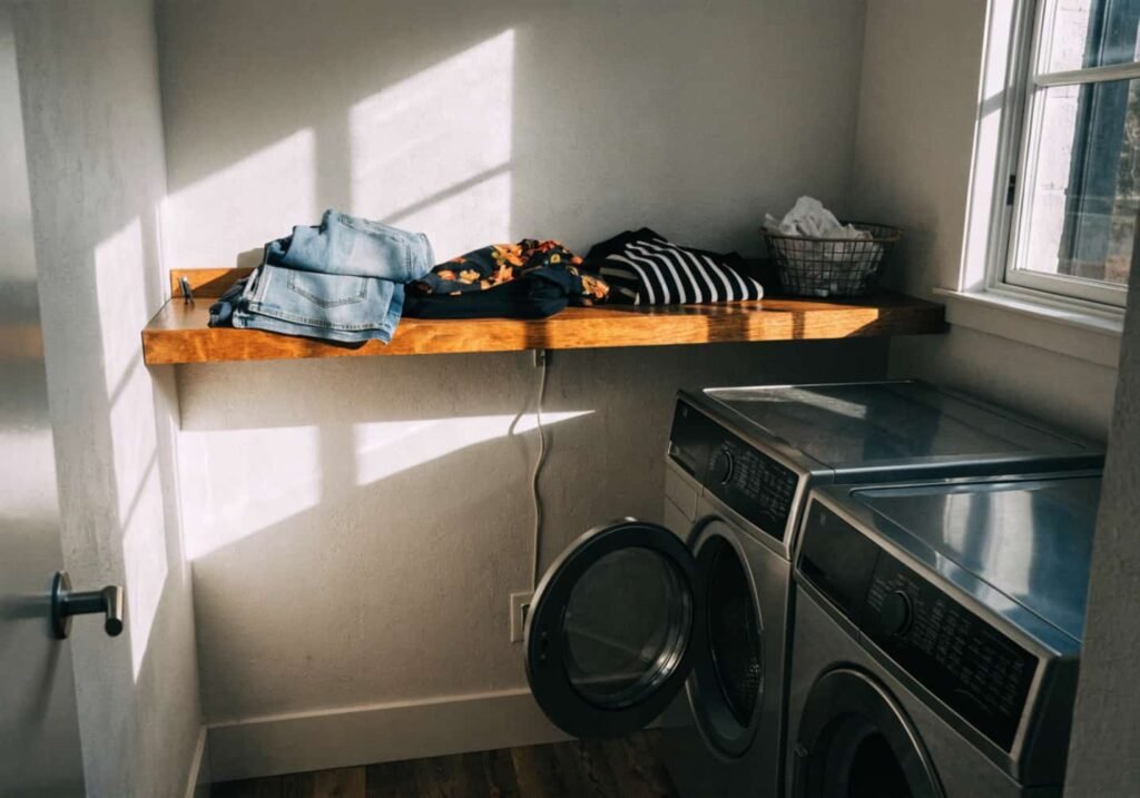 Fold-out counter built into a full-height laundry cabinet wall
