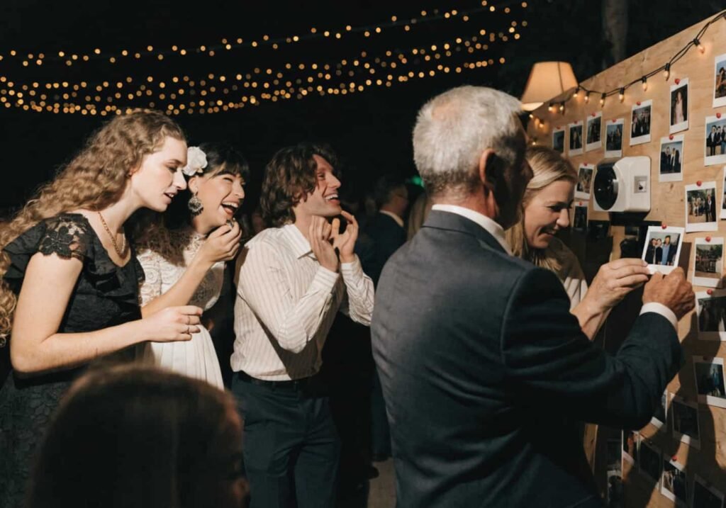 Guests using an instant photo booth at a wedding reception