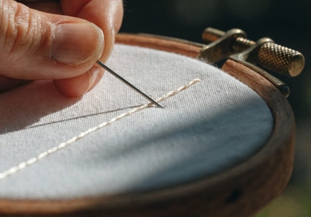 Backstitch technique creating solid outline on embroidery hoop fabric