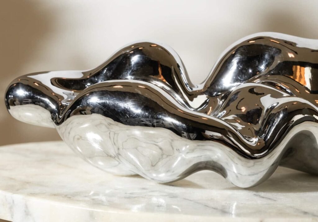 Liquid metal aesthetic chrome decorative object on marble surface
