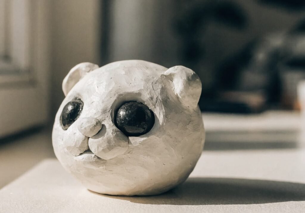Small handmade clay animal face figure with simple rounded features