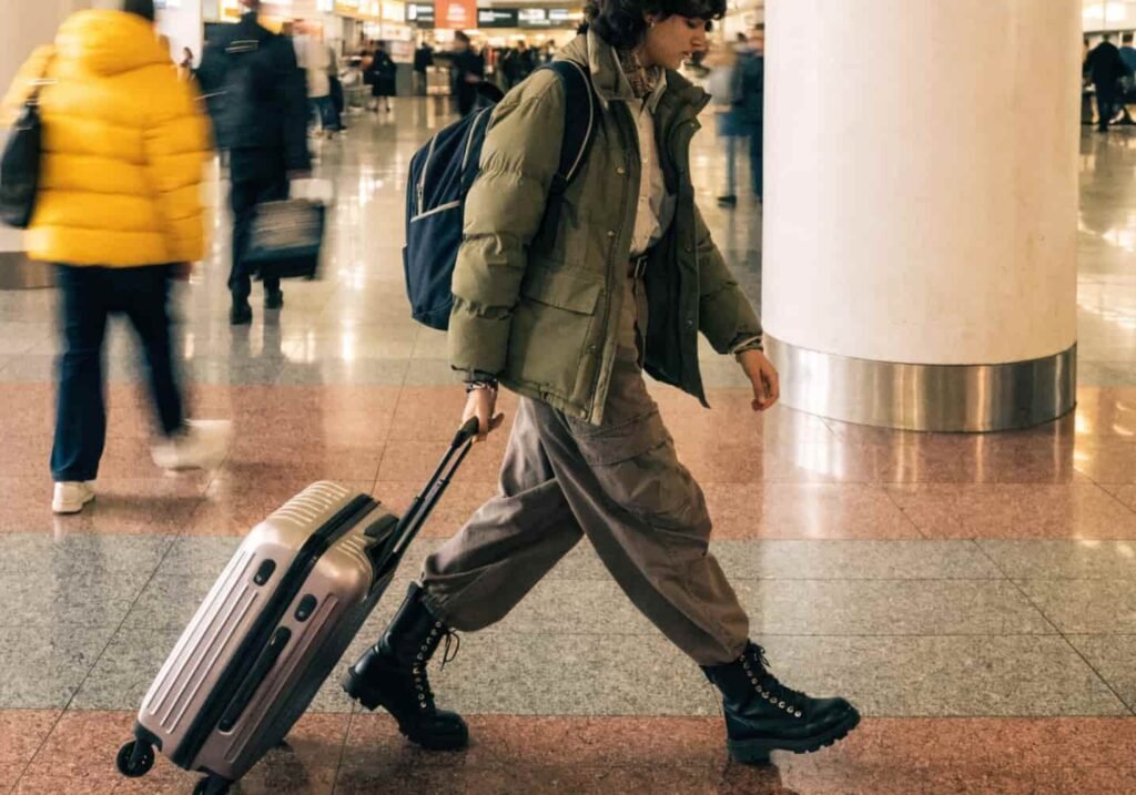 Traveler wearing a heavy jacket and boots while walking through the airport