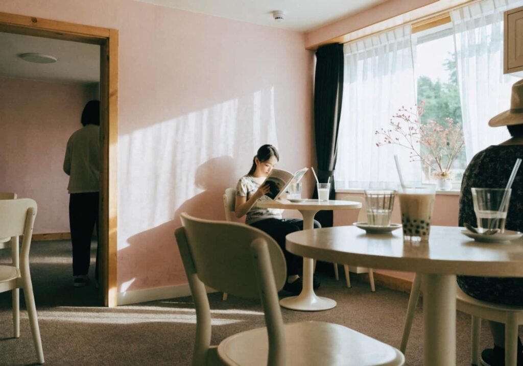 Soft pastel aesthetic cafe interior with blush pink walls and cream tones