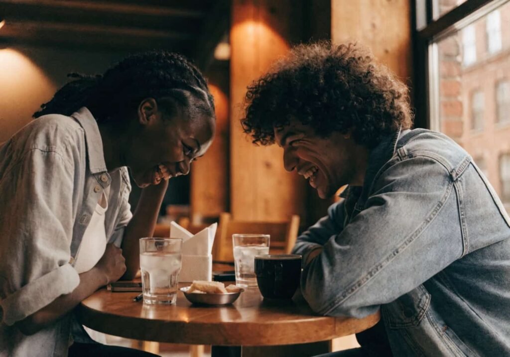 Couple laughing together candidly at a cafe table