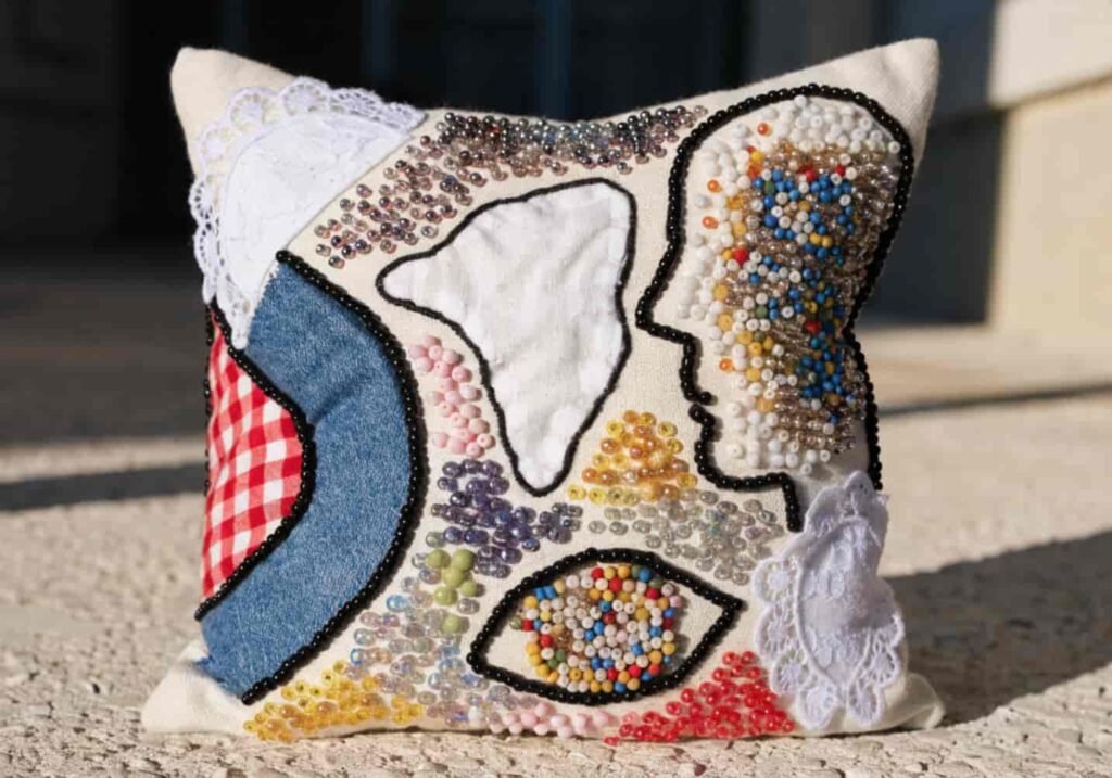 Cushion cover with mixed-media appliqué and embroidered detailing