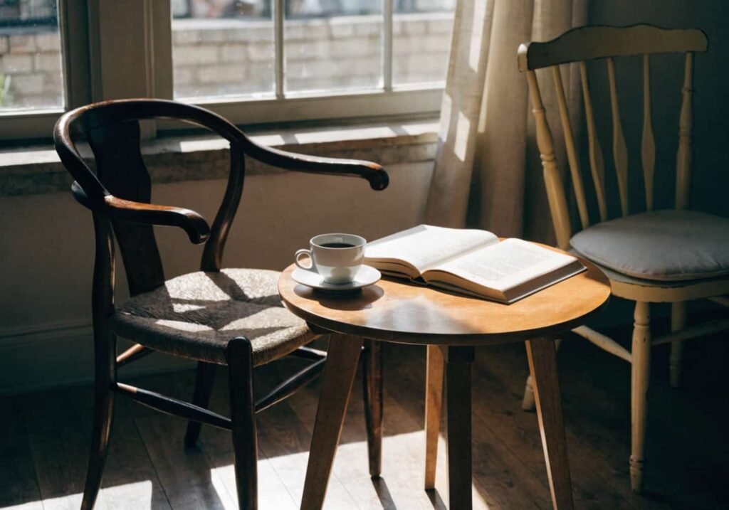 small round wooden cafe table by a sunny window