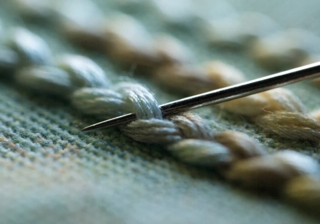 Split stitch technique creating smooth curved textured line on fabric