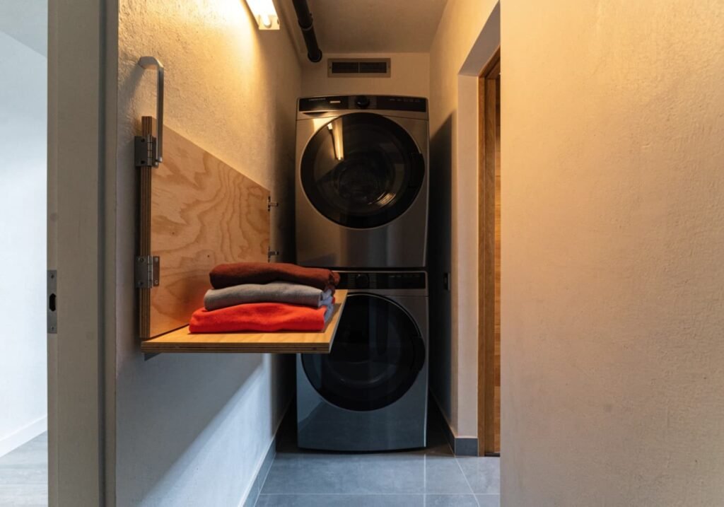 Built-in fold shelf inside a small closet laundry setup