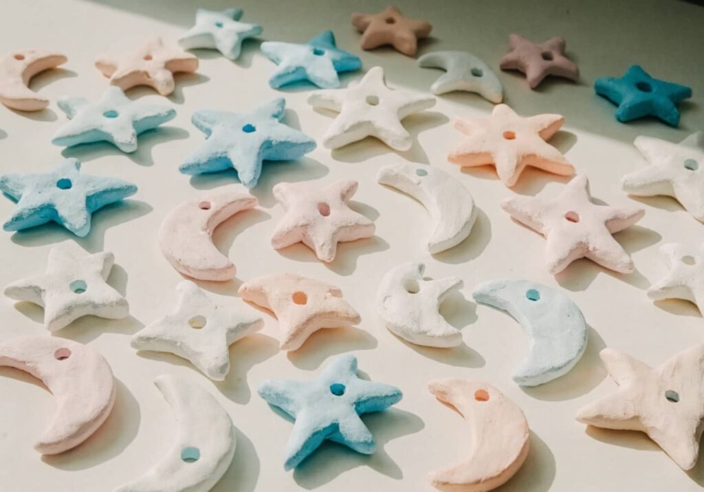 Small pastel clay star and moon shapes with holes for hanging charms