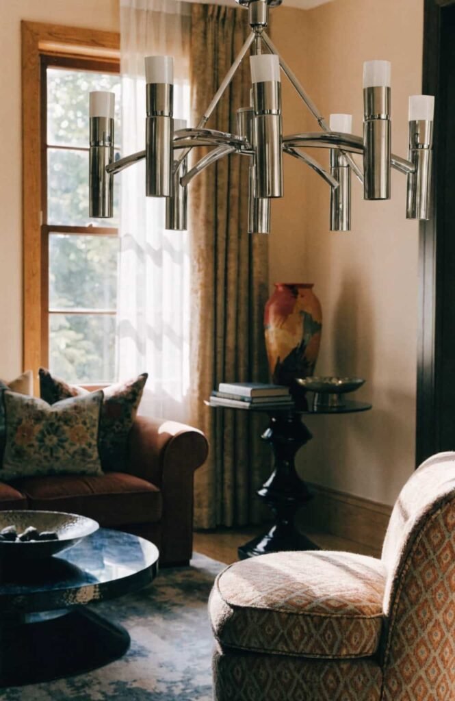 Multi-arm chrome chandelier catching sunlight in an elegant living room