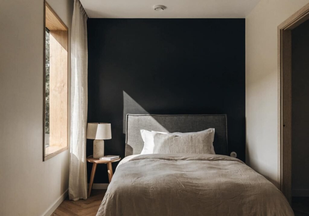 Bedroom featuring a black wall behind the bed as the room's natural focal point.