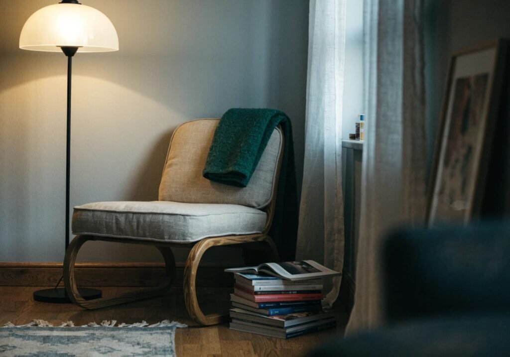 Calm gray living room corner with reading chair and warm lamp light