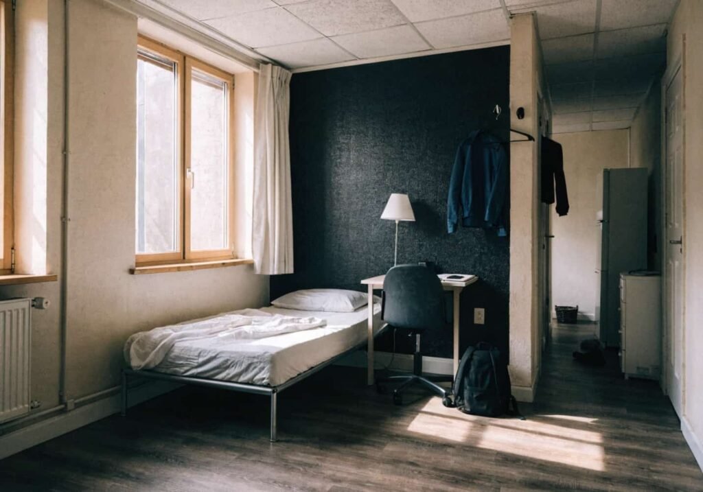 Peel-and-stick black textured wallpaper used as a renter-friendly accent wall behind a bed.