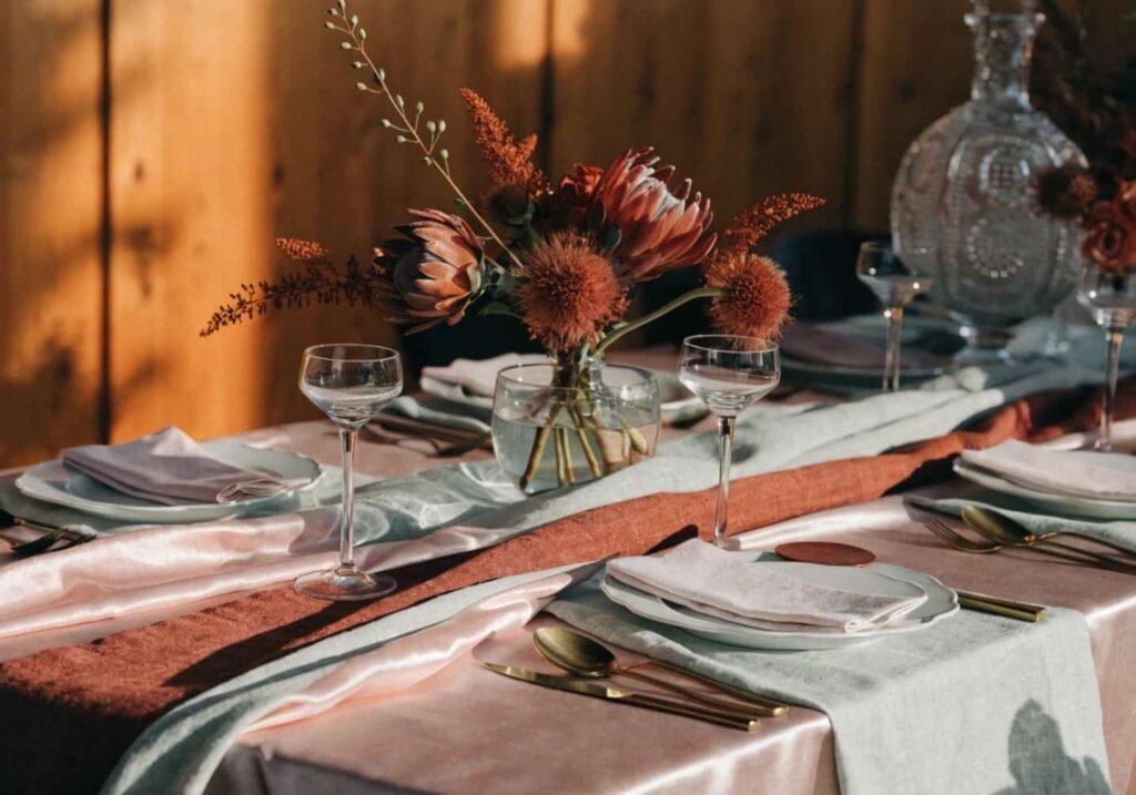 Pastel wedding tablescape anchored by a terracotta runner for contrast.