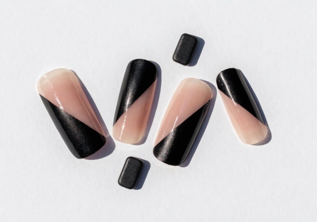 Minimalist geometric nail art with a diagonal black line accent on a nude base
