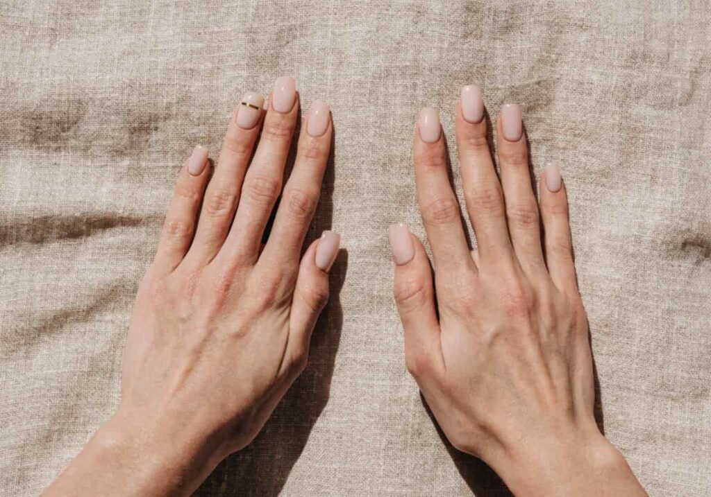 Minimalist nail art design featuring a single thin gold accent line on a nude manicure.