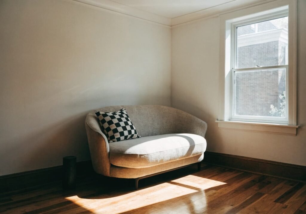 A compact loveseat sofa saving floor space in a small, sunlit living room.