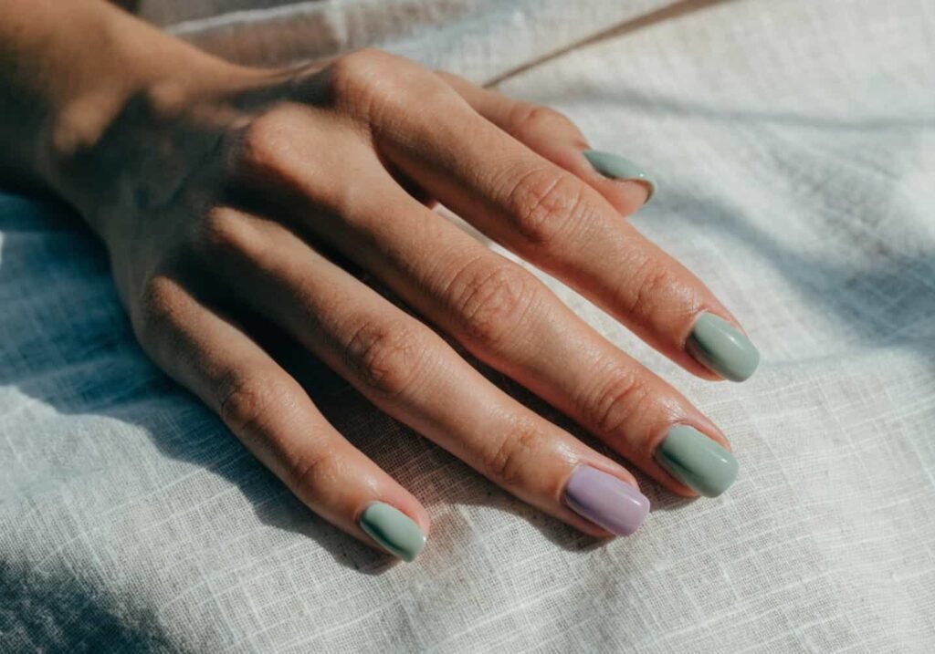Nails in sheer pastel sage green and lilac with a jelly-like finish