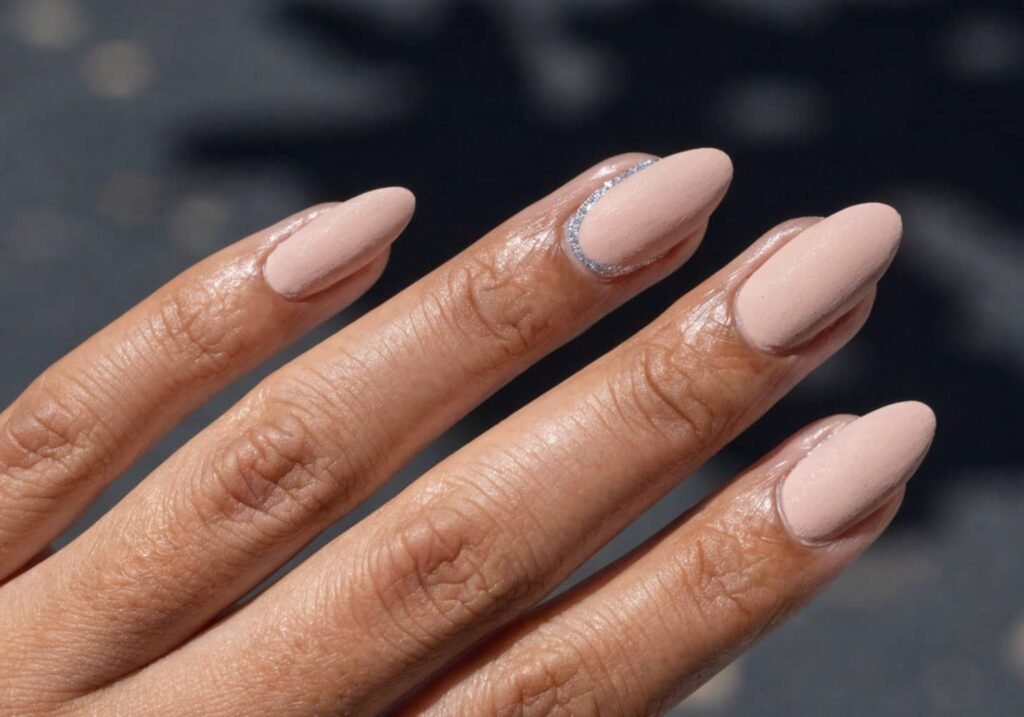 Silver glitter accent nail with matte nude nails