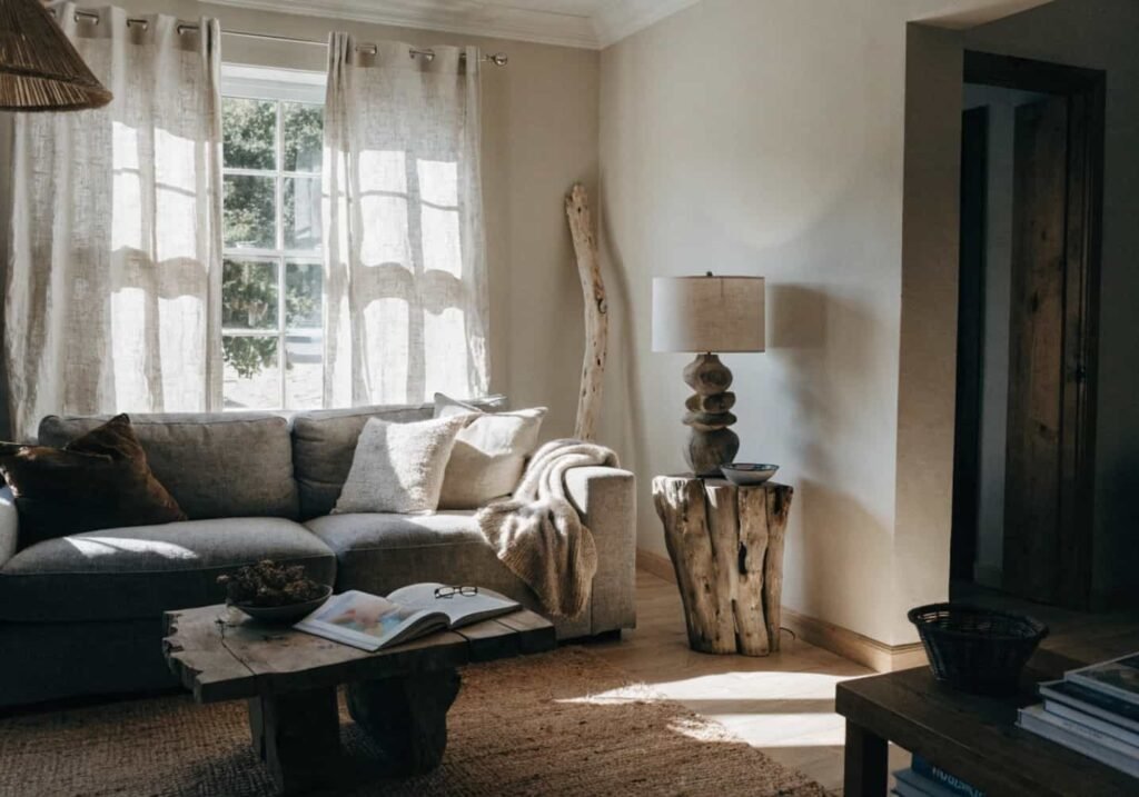 Coastal boho grey couch with driftwood and linen curtain accents
