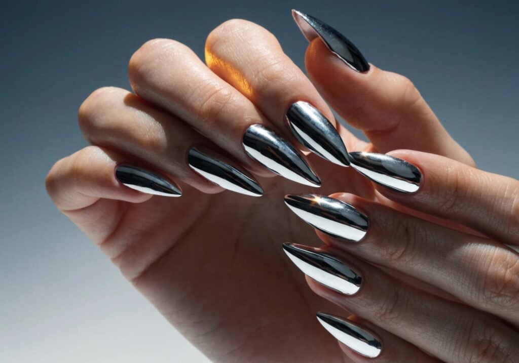Silver chrome nail finish reflecting light on manicured hands