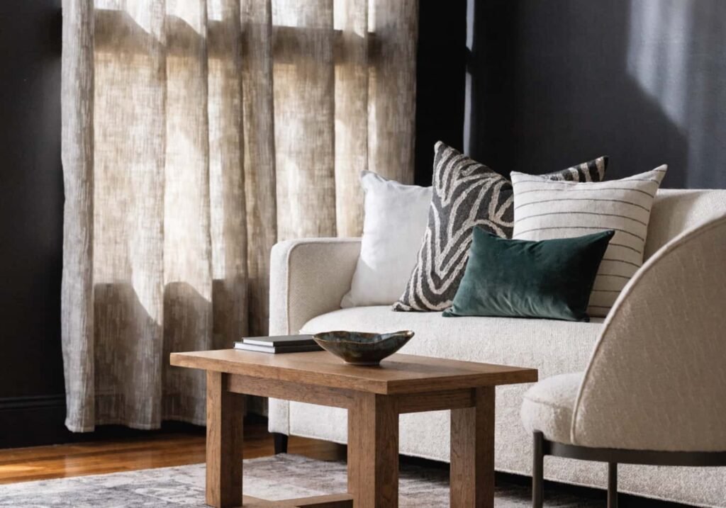 Black accent wall paired with light cream furniture for a balanced, elegant contrast.