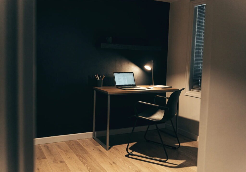 Small home office made cozy with a black accent wall