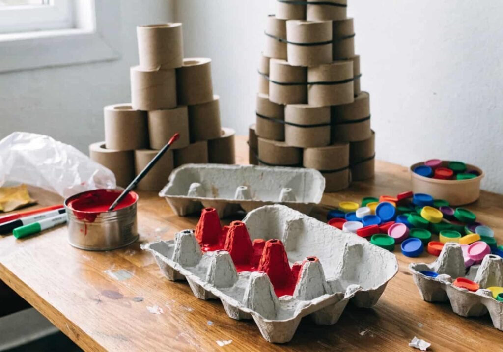 Recycled craft materials including egg cartons and toilet paper rolls used for kindergarten art projects