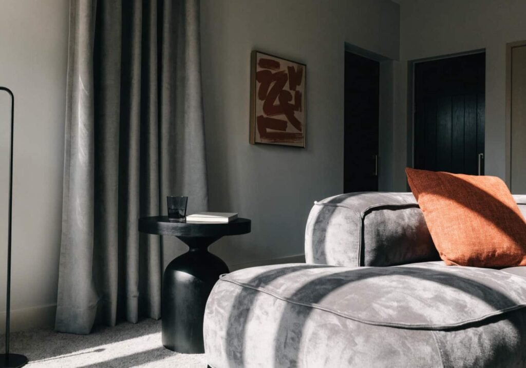 Rust-orange accent cushion adding warmth to a gray boho living room