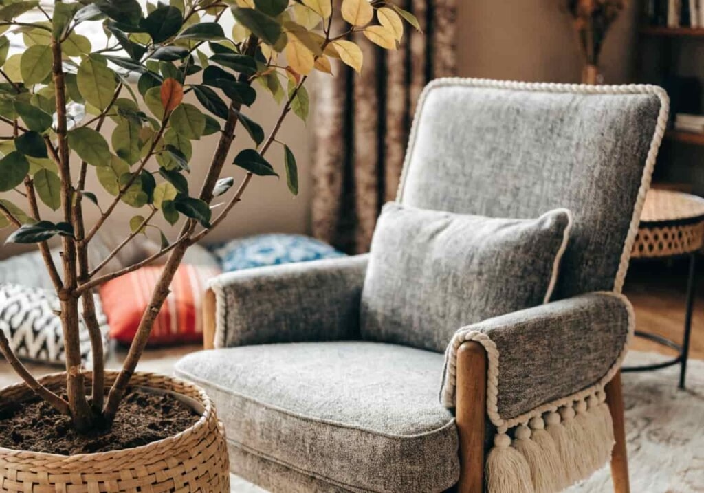 Leafy plant in woven planter beside grey boho armchair