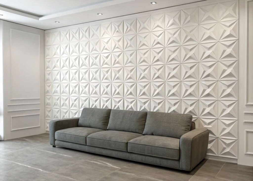 geometric white 3D textured wall panels installed as an accent wall behind a gray sofa