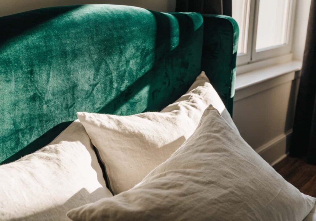 Emerald velvet headboard adding texture to a romantic bedroom