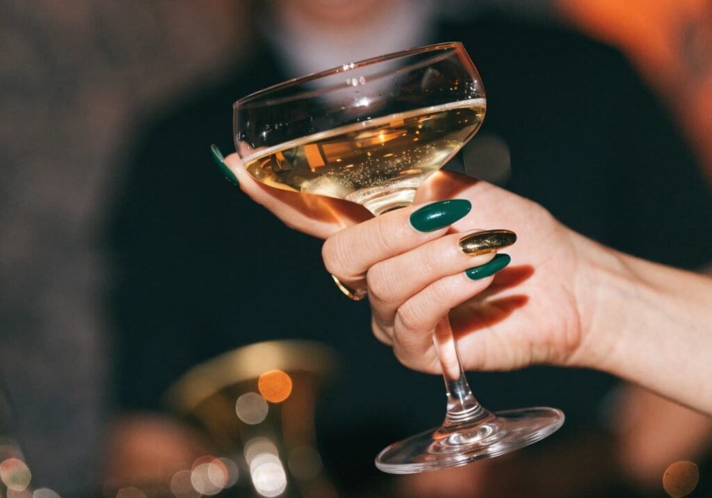 Elegant party manicure with emerald nails and gold accent nail