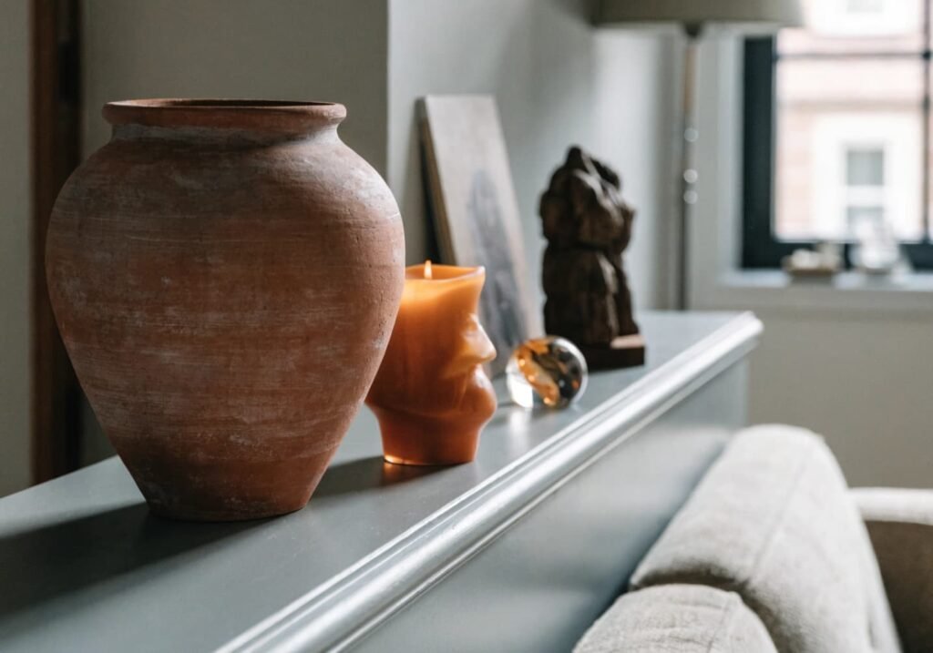Terracotta and rust accents warming a grey living room shelf