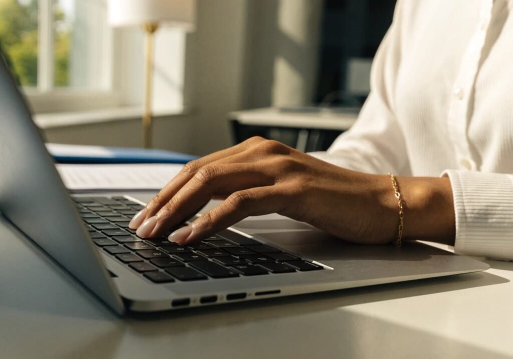 Office-appropriate quiet luxury manicure in sheer neutral tone while typing